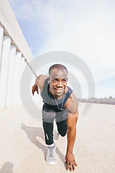 Athletic Man in Running Start Position and Looking Into the Distance at the Park