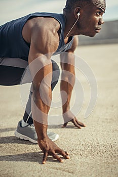Athletic Man in Running Start Position and Looking Into the Distance at the Park