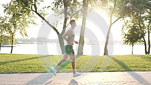 athletic man running in sunrise park outdoor, anaerobic load