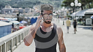 Athletic man at the seaside calling on cell phone