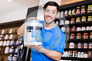 Athletic man seller demostration sport nutrition products in shop photo