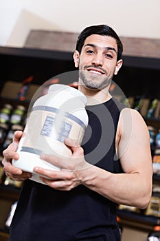 Athletic man seller demostration sport nutrition products in shop photo