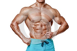 athletic man showing abdominal muscles without fat, isolated over white background. Muscular male fitness model abs