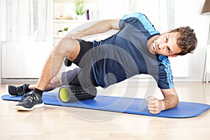 Athletic Man in Side Planking Using Foam Roller