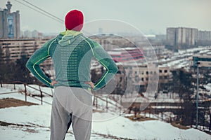 Athletic man standing outdoors looking at the cityscape