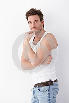 Athletic man standing at wall in undershirt