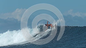 Athletic man on summer holiday does a sharp turn with his surfboard on big wave.