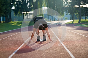 Athletic man on track starting to run. Healthy fitness concept with active lifestyle.