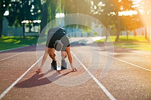 Athletic man on track starting to run. Healthy fitness concept with active lifestyle.