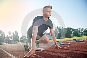 Athletic man on track starting to run. Healthy fitness concept with active lifestyle.