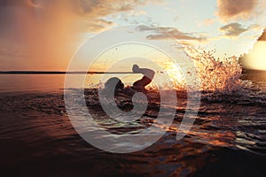 Athletic man is trained to swim in a lake at sunset. It flies a lot of water splashing photo