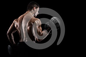 Athletic man training biceps on black background