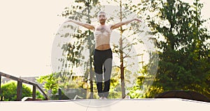 Athletic man training yoga pose and doing yoga breathing exercise while raising hands to the sky