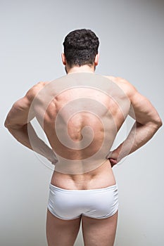 Athletic man turned back on white background.