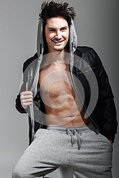 Athletic man wearing hoodie jacket. Studio shot