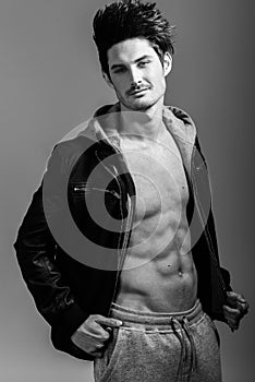 Athletic man wearing hoodie jacket. Studio shot