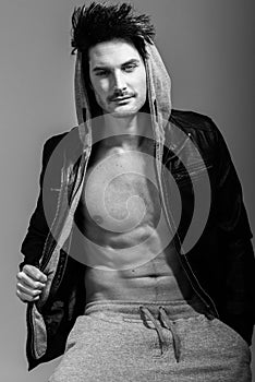 Athletic man wearing hoodie jacket. Studio shot