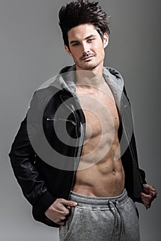 Athletic man wearing hoodie jacket. Studio shot