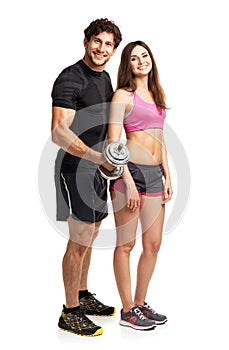 Athletic man and woman with dumbbells on the white