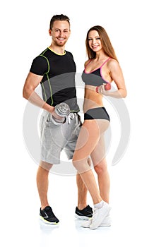 Athletic man and woman with dumbbells on the white