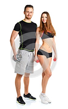 Athletic man and woman with dumbbells on the white