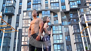 Athletic man and woman after fitness exercise at the gym outdoors.