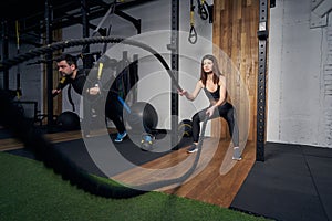 Athletic man and woman working out together in gym