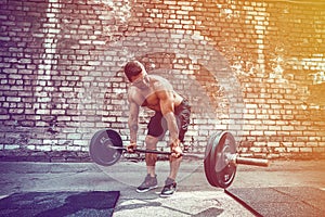 Athletic man working out with a barbell. Strength and motivation
