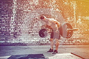 Athletic man working out with a barbell. Strength and motivation