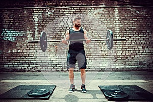 Athletic man working out with a barbell. Strength and motivation. Biceps exercise.