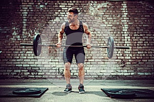 Athletic man working out with a barbell. Strength and motivation. Exercise for the muscles of the back