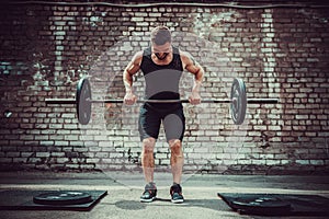 Athletic man working out with a barbell. Strength and motivation. Exercise for the muscles of the back