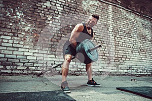 Athletic man working out with a barbell. Strength and motivation. Exercise for the muscles of the back