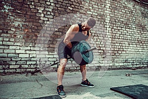 Athletic man working out with a barbell. Strength and motivation. Exercise for the muscles of the back