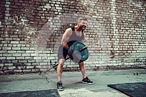 Athletic man working out with a barbell. Strength and motivation. Exercise for the muscles of the back