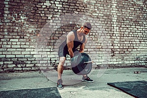 Athletic man working out with a barbell. Strength and motivation. Exercise for the muscles of the back