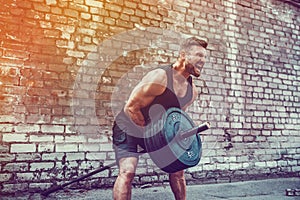 Athletic man working out with a barbell. Strength and motivation. Exercise for the muscles of the back