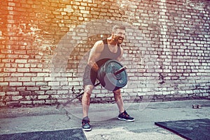 Athletic man working out with a barbell. Strength and motivation. Exercise for the muscles of the back