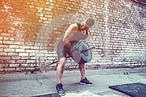 Athletic man working out with a barbell. Strength and motivation. Exercise for the muscles of the back