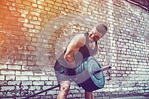 Athletic man working out with a barbell. Strength and motivation. Exercise for the muscles of the back