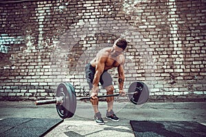 Athletic man working out with a barbell. Strength and motivation. Exercise for the muscles of the back