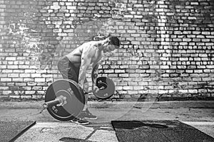 Athletic man working out with a barbell. Strength and motivation. Exercise for the muscles of the back