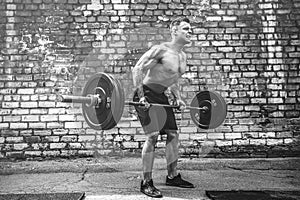 Athletic man working out with a barbell. Strength and motivation. Exercise for the muscles of the back