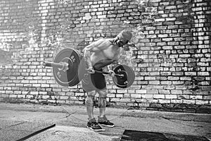 Athletic man working out with a barbell. Strength and motivation. Exercise for the muscles of the back