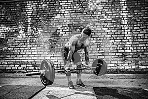 Athletic man working out with a barbell. Strength and motivation. Exercise for the muscles of the back