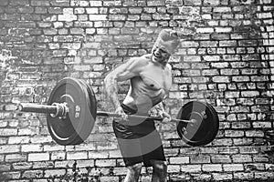 Athletic man working out with a barbell. Strength and motivation. Exercise for the muscles of the back