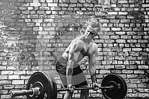 Athletic man working out with a barbell. Strength and motivation. Exercise for the muscles of the back