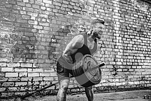 Athletic man working out with a barbell. Strength and motivation. Exercise for the muscles of the back