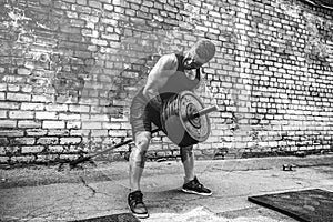 Athletic man working out with a barbell. Strength and motivation. Exercise for the muscles of the back