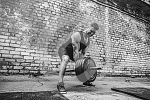 Athletic man working out with a barbell. Strength and motivation. Exercise for the muscles of the back